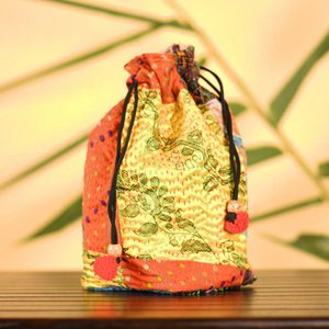 Colourful potli in traditional Kantha patchwork on silk exteriors